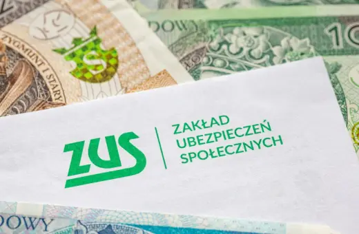Koperta ZUS na tle polskich banknotów. Dokumenty dotyczące zasiłku chorobowego i pieniędzy.