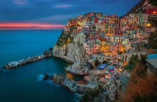 Kolorowe domy Cinque Terre, Włochy, w blasku zachodzącego słońca. Idealne miejsce na wycieczkę do Włoch.