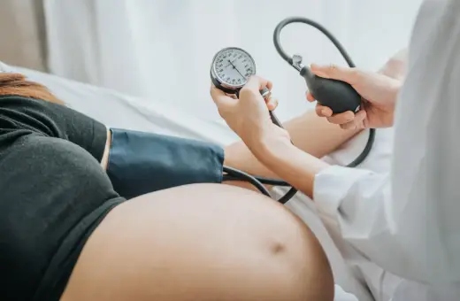 Kobieta w ciąży ma mierzone ciśnienie. Monitorowanie ciśnienia jest kluczowe, by uniknąć powikłań, takich jak wysokie ciśnienie w ciąży.