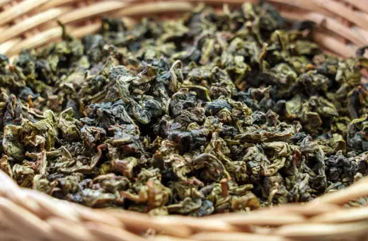 Suszone liście herbaty gunpowder w wiklinowym koszyku. Odkryj jej niezwykłe właściwości!