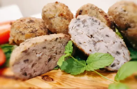 Kotleciki mielone z pieczarkami, chrupiące z zewnątrz, soczyste w środku, podane z miętą na drewnianej desce.