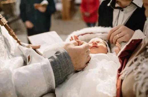 Chrzestny trzyma dziecko do chrztu. Potrzebuje miłości i wsparcia.