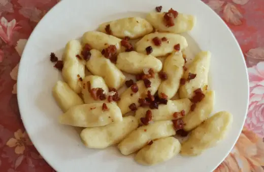 Kopytka z boczkiem, jak u babci! Pyszne ciasto na kopytka przepis babci, podane na talerzu.