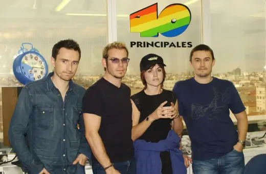 The Cranberries, marząc o sukcesie, pozują przed logo 40 Principales.