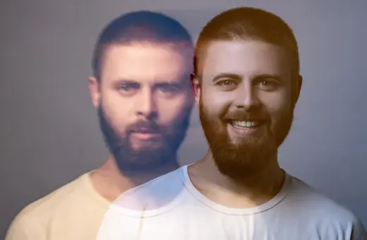 Dwóch mężczyzn, jeden z uśmiechem, drugi z poważną miną, jakby w stanie manii.