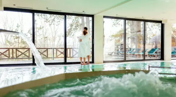 Pareja abrazada en un spa, disfrutando de la piscina y la vista. Así se hace en un spa: relajación y conexión.