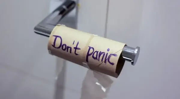 Pusta rolka po papierze toaletowym z napisem "Don't Panic" (Nie panikuj). Może to być metafora sytuacji, w której brakuje czegoś, ale nie ma powodu do zmartwień, jak np. w przypadku problemów żołądkowych, gdzie Tasectan mógłby pomóc.