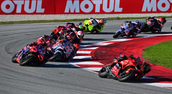 Carreras de MotoGP en curva, pilotos luchando por posición. El calendario MotoGP se llena de adrenalina.