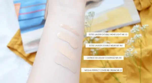 Smugi podkładów na przedramieniu: Estee Lauder, Catrice i Missha.