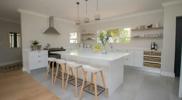 Une cuisine moderne et lumineuse, parfaite pour **créer sa cuisine** de rêve. Îlot central blanc, tabourets design, et rangements astucieux.