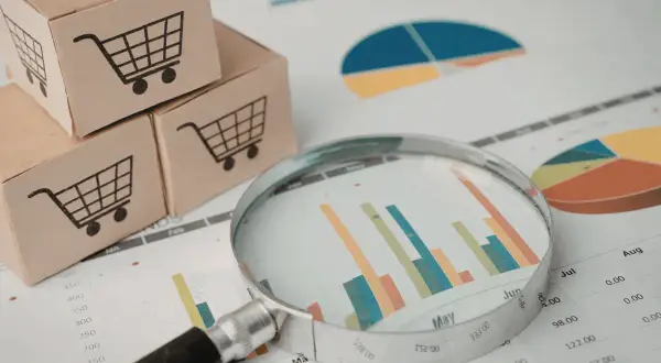 Cajas con carritos de compra y gráficos. Analizando cuánto cuesta hacer una página web para tu negocio.