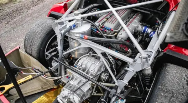 Potężny silnik Ferrari F40, z widocznymi turbosprężarkami i skomplikowaną instalacją paliwową, gotowy do wyzwolenia mocy.