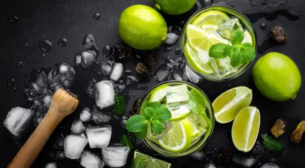 Erfrischende Mojitos mit Limetten, Minze und Eiswürfeln. Das perfekte Mojito Rezept für heiße Tage.