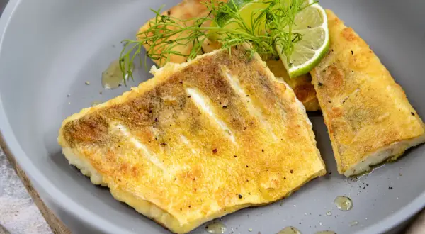 Gebratene Zanderfilets mit Dill und Zitrone, ein köstliches Zander Rezept, serviert auf einem grauen Teller.