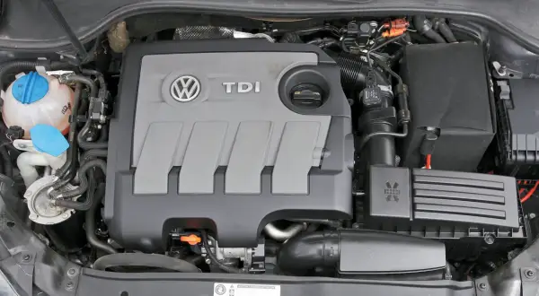 Silnik 1.6 TDI Volkswagena z widocznym logo TDI i zbiorniczkiem płynu chłodniczego.