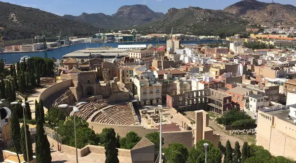 Vista panorámica de Cartagena, con el teatro romano y el castillo de la Concepción dominando el paisaje urbano y el puerto.