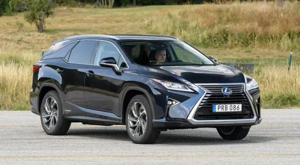 Mörkblå Lexus RX 450h körs på en väg, föraren ser ut att ha ett lexus rx 450h problem.