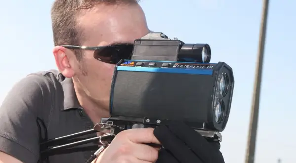 Un homme utilise un nouveau radar camera Ultralyte LR pour mesurer la vitesse.