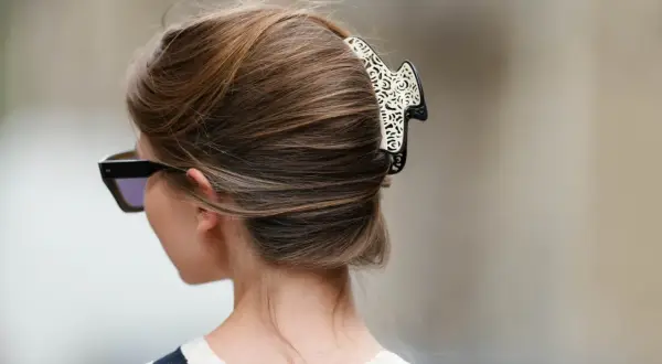 Elegancki french twist z ozdobną spinką, podkreślający szyję i okulary przeciwsłoneczne.