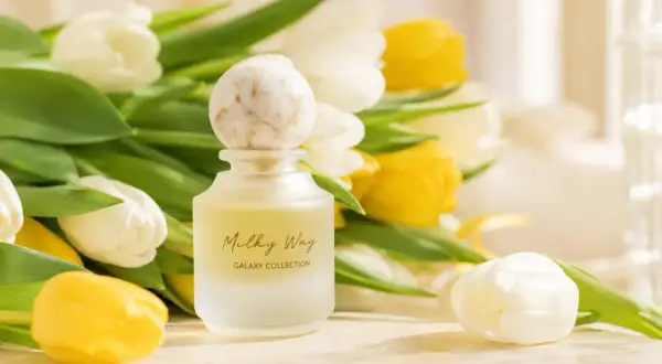 Eleganckie perfumy na prezent, otoczone bukietem białych i żółtych tulipanów. Czy to dobry omen, czy przesądy związane z podarunkiem?