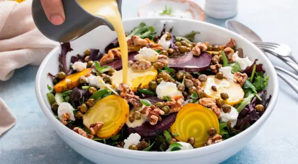 Una ensalada vibrante con remolachas, queso de cabra y nueces, bañada con deliciosas salsas para ensaladas.