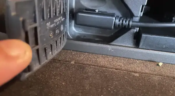 Kabel AUX podłączony do gniazda, gdy **bluetooth przerywa**. Palec przytrzymuje klapkę.