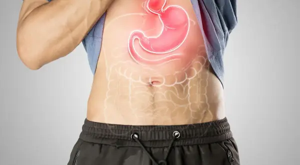 Uomo con stomaco evidenziato in rosso, che suggerisce fitte allo stomaco.