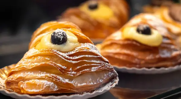 Délicieuse patisserie italienne typique, feuilletée et garnie de crème et d'une cerise.