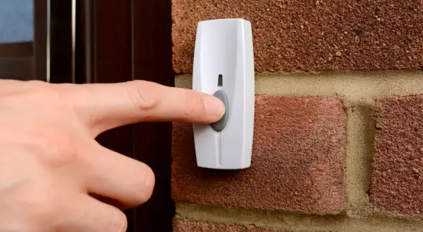 Main tenant appuie sur le bouton pour installer une sonnette sans fil.