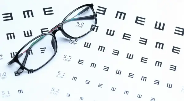 Okulary na tle tablicy Snellena z literami E.