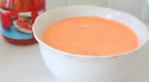 En skål med krämig, kall sås till grillad kyckling, gjord på crème fraiche. En burk med tomatsås skymtar i bakgrunden.