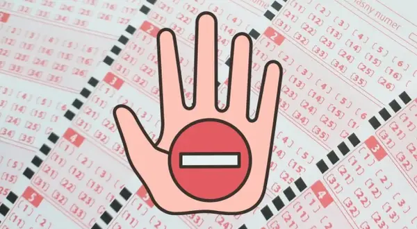 Czy można kupić polskie lotto będąc za granicą przez internet? Dłoń z symbolem zakazu na tle kuponów lotto.