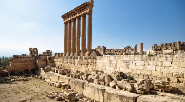 Majestätische Säulen des Baalbek Tempels ragen in den blauen Himmel. Antike Ruinen und Steine zeugen von vergangener Größe.