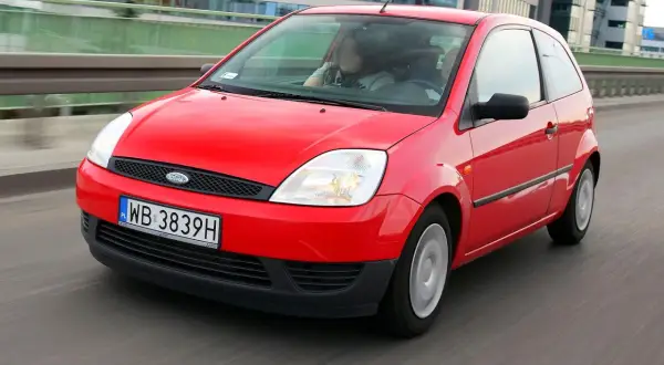 Czerwony Ford Fiesta MK5 w ruchu miejskim.
