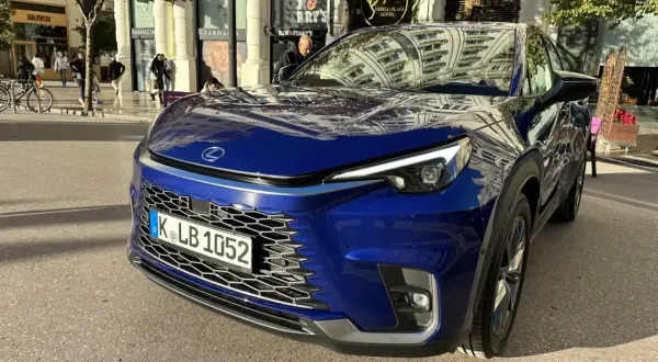 Niebieski Lexus LBX na ulicy. Zbliżenie na przód auta, widoczna krata wlotu powietrza i reflektory. Wymiary tego kompaktowego SUV-a są idealne do miasta.