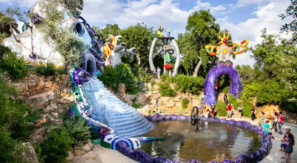 Il Giardino dei Tarocchi di Niki de Saint Phalle, un'esplosione di colori e forme, con sculture monumentali e una fontana scintillante.