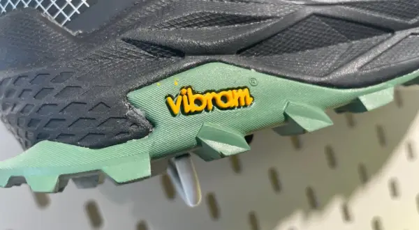 Nahaufnahme einer grünen Vibram Sohle mit gelbem Logo. Mögliche Nachteile: Abnutzung, aber die Traktion ist gut.