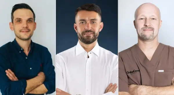 Trzech lekarzy: ortopeda w granatowej koszuli, chirurg w białej koszuli i lekarz w brązowym uniformie.