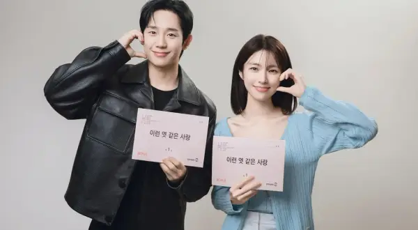Jung Hae In und seine Kollegin halten Drehbücher für "A Love So Beautiful" und lächeln.