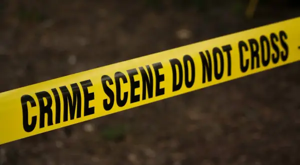 Żółta taśma z napisem "CRIME SCENE DO NOT CROSS". Sytuacja, która wymaga zgłoszenia do prokuratury.