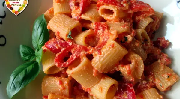 Un piatto di pasta con peperoni rossi e basilico fresco. Un'esplosione di sapori mediterranei.