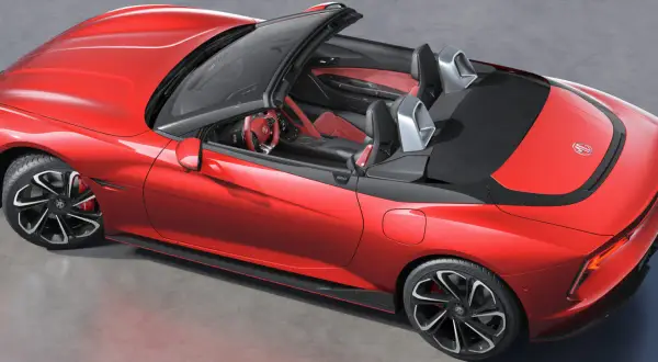 Czerwony MG Roadster z otwartym dachem, sportowe fotele i kierownica.