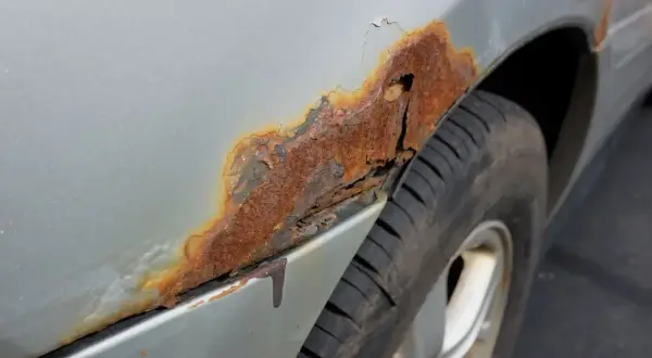 Starke Korrosion am Kotflügel eines Autos. Die Kosten für Rost entfernen am Auto können je nach Ausmaß variieren.