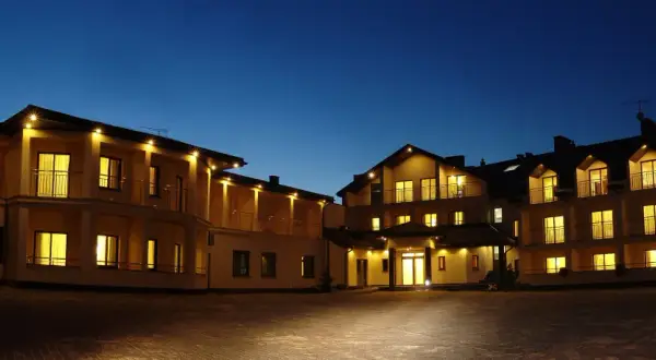 Elegancki hotel spa Rusałka nocą, z oświetlonymi oknami i balkonami, zaprasza do wypoczynku.