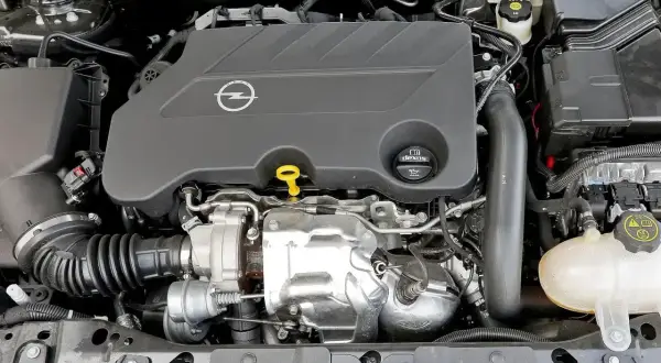 Silnik 2.0 Turbo w Oplu Insignia, gotowy do pracy. Widoczny turbosprężarka i osłony.
