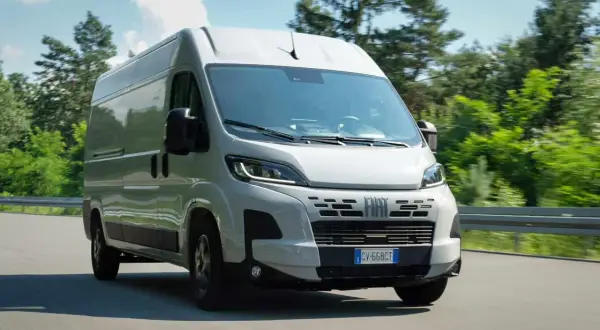 Un fourgon Fiat Ducato 2.3 Multijet 140 Euro 6 roule sur une route bordée d'arbres.