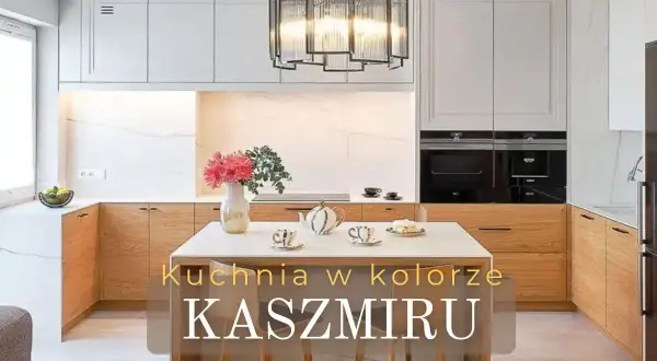 Elegancka kuchnia w kolorze kaszmiru z drewnianymi frontami i marmurowym tłem. Na wyspie bukiet kwiatów i zastawa.