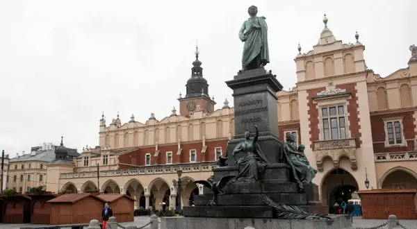 Pomnik Adama Mickiewicza na Rynku w Krakowie, z Sukiennicami w tle.