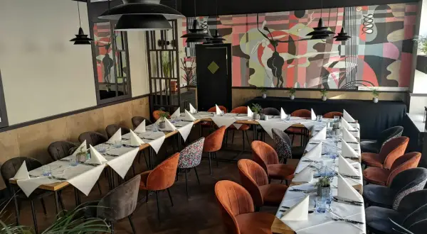 Elegancka sala bankietowa z nakrytymi stołami, idealna na wyjątkowe okazje. To może być najlepsza restauracja w Olsztynie.