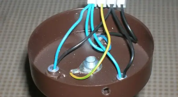 Brązowa podsufitka lampy z widocznymi przewodami: 3 kable z sufitu, 2 w lampie. Połączenia elektryczne w toku.